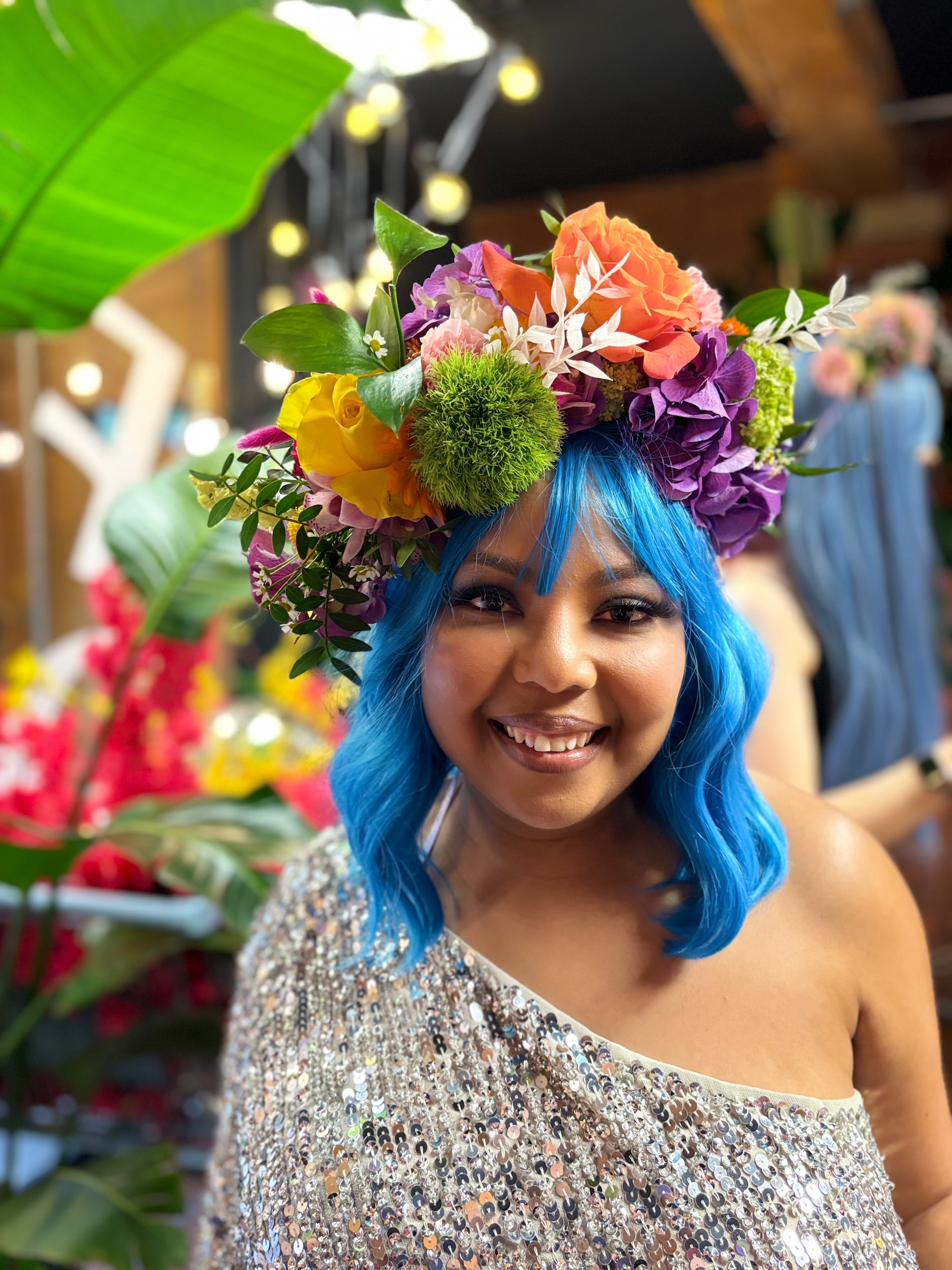 Woman with blue hair, with a fresh flower crown at a workshop for a hen party in Manchester.