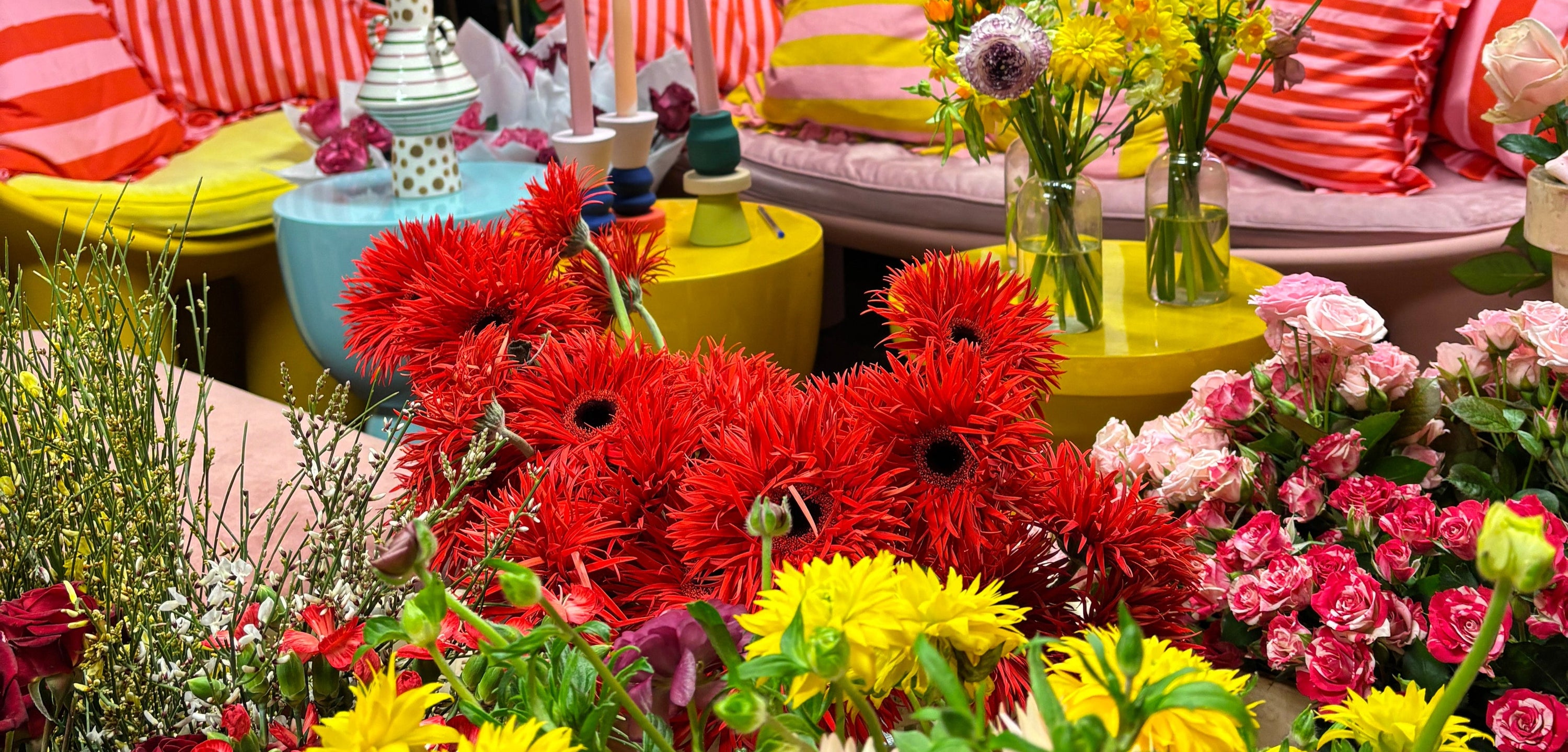 Florist at the Frog Flower Flower School in Manchester, UK. Red gerbera, spray roses, butterfly ranunculus, ginestra, broom.
