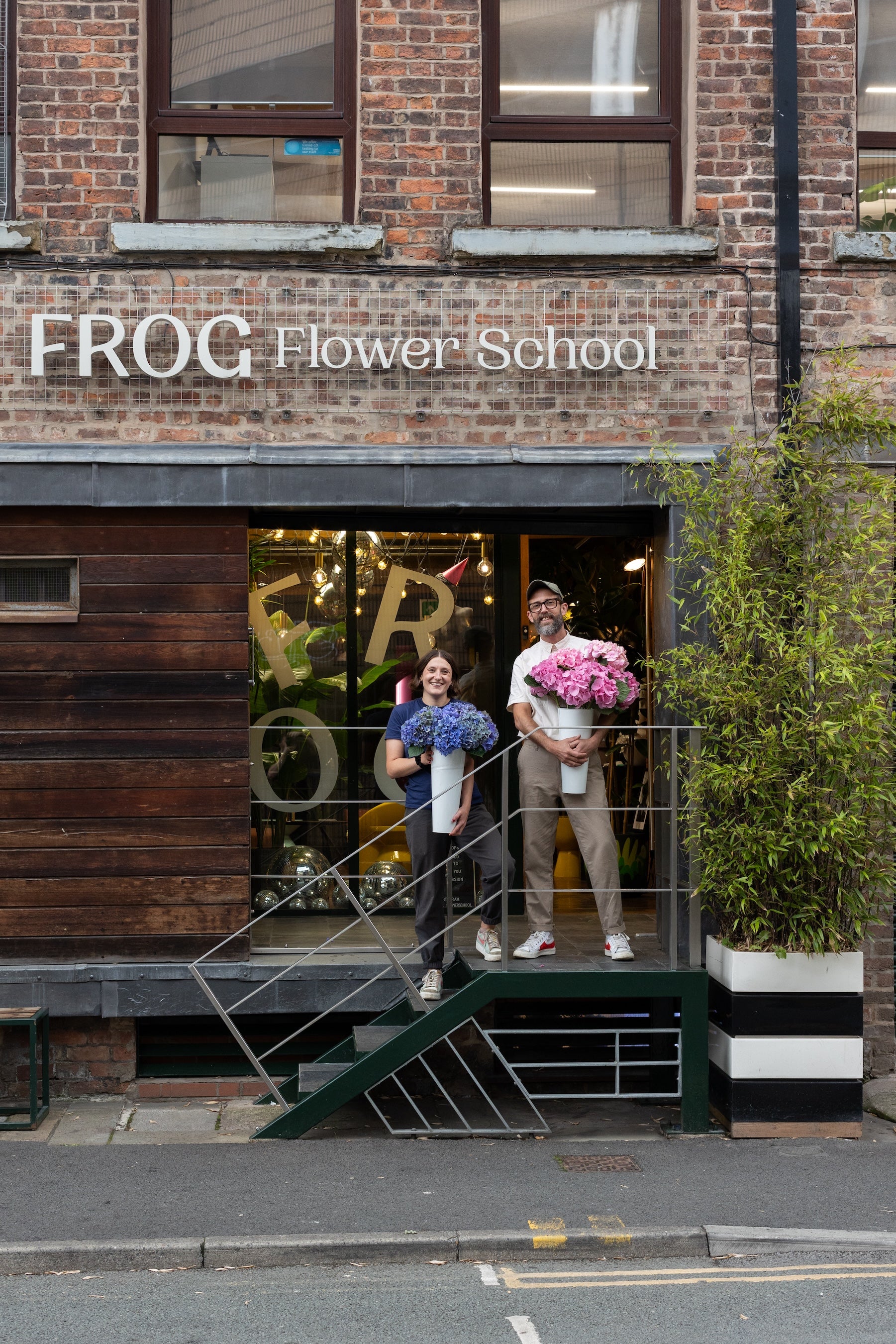 David Jayet Laraffe and Suzie Clarke at Frog Flower School in Manchester, Northern Quarter. Florist and workshops. David and Suzie are stood in front of our industrial studio building.