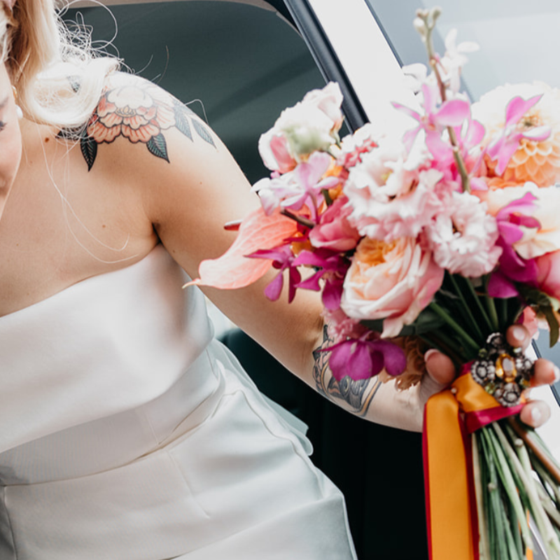 Bridal bouquet of peach and hot pink flowers in a modern style for an alternative wedding in Manchester.