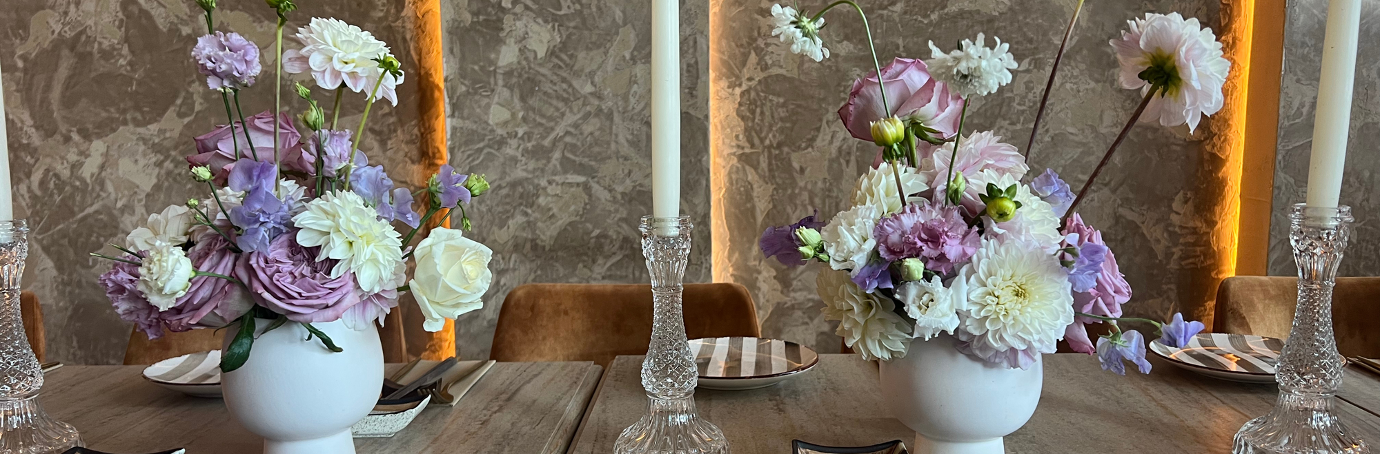 Event flowers for Manchester and Liverpool. White ceramic vases with white dahlias, lilac roses, sweet peas and scabiosa. Crystal candle sticks on a table scape.