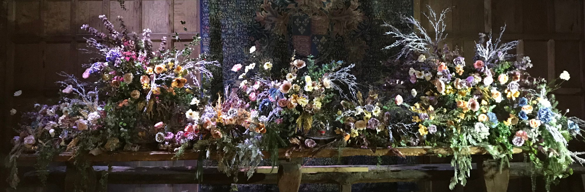 Banqueting table for Haddon Hall in Cheshire. Opulent arrangements of flowers like roses, dahlias, poppies, trailing foliages, large branches!